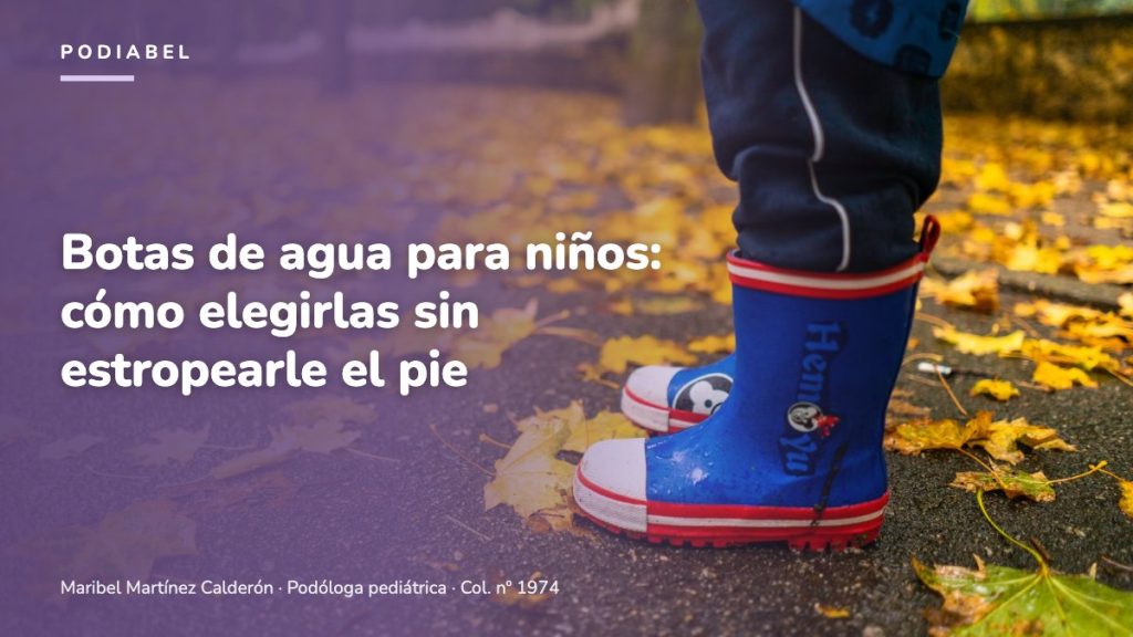 Niño con botas de agua azules caminando sobre hojas de otoño